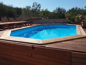 Enjoy a refreshing swim in the pool surrounded by a wooden deck.