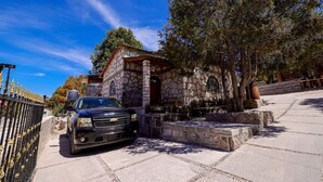 A stone building with a car parked in front. - Cabañas Las Gemelas Barrancas del Cobre (Urique)