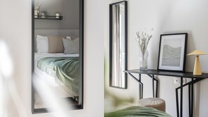 Une chambre à coucher moderne avec un lit, une table de chevet et un miroir.