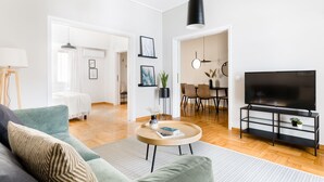 Un salon moderne comprenant un canapé, une table basse, un meuble pour la télévision et un coin repas.