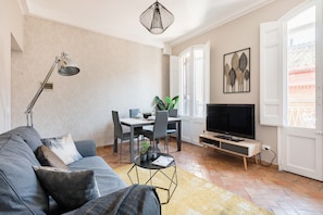 A living room with a sofa, TV, dining table, and chairs. - Maison Babuino with a panoramic terrace (Roma)