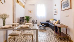 Una sala de estar con comedor, un sofá, una mesa de centro y un piso con diseño.