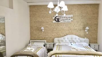 Une chambre d’hôtel avec deux lits, un mur décoré d’un motif en briques, un lustre et une enseigne décorative.