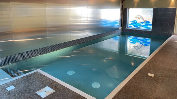 An indoor swimming pool with clear water, a tiled floor, and a wooden ceiling. - Georgian House with Indoor Swimming Pool (Willsbridge)