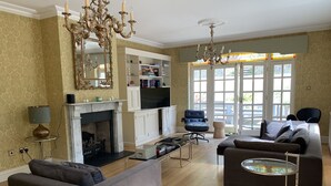 A spacious living room with a fireplace, a television, and comfortable seating. - Georgian House with Indoor Swimming Pool (Willsbridge)
