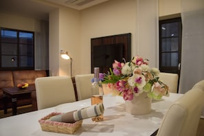Enjoy a stylish dining experience with a beautifully set table, fresh flowers, and a bottle of wine.