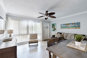 Relax in this stylish living area with a dining table, sofa, and potted plant.
