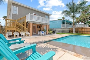 Ein zweistöckiges Haus mit Pool, Außenbereich und einer Holzterrasse.