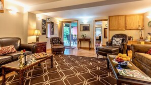 A spacious living room with leather sofas, a coffee table with a fruit bowl, and a patterned rug. - The Privacy of a home & Perks of a Resort! Pool, Tennis, Views, Dogs, 6 baths! (Manchester)