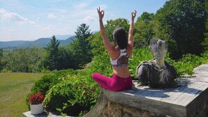 A person sitting on a stone ledge outdoors with a scenic view in the background. - The Privacy of a home & Perks of a Resort! Pool, Tennis, Views, Dogs, 6 baths! (Manchester)