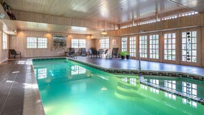 A large indoor swimming pool with a wooden interior, multiple windows, and seating areas. - The Privacy of a home & Perks of a Resort! Pool, Tennis, Views, Dogs, 6 baths! (Manchester)
