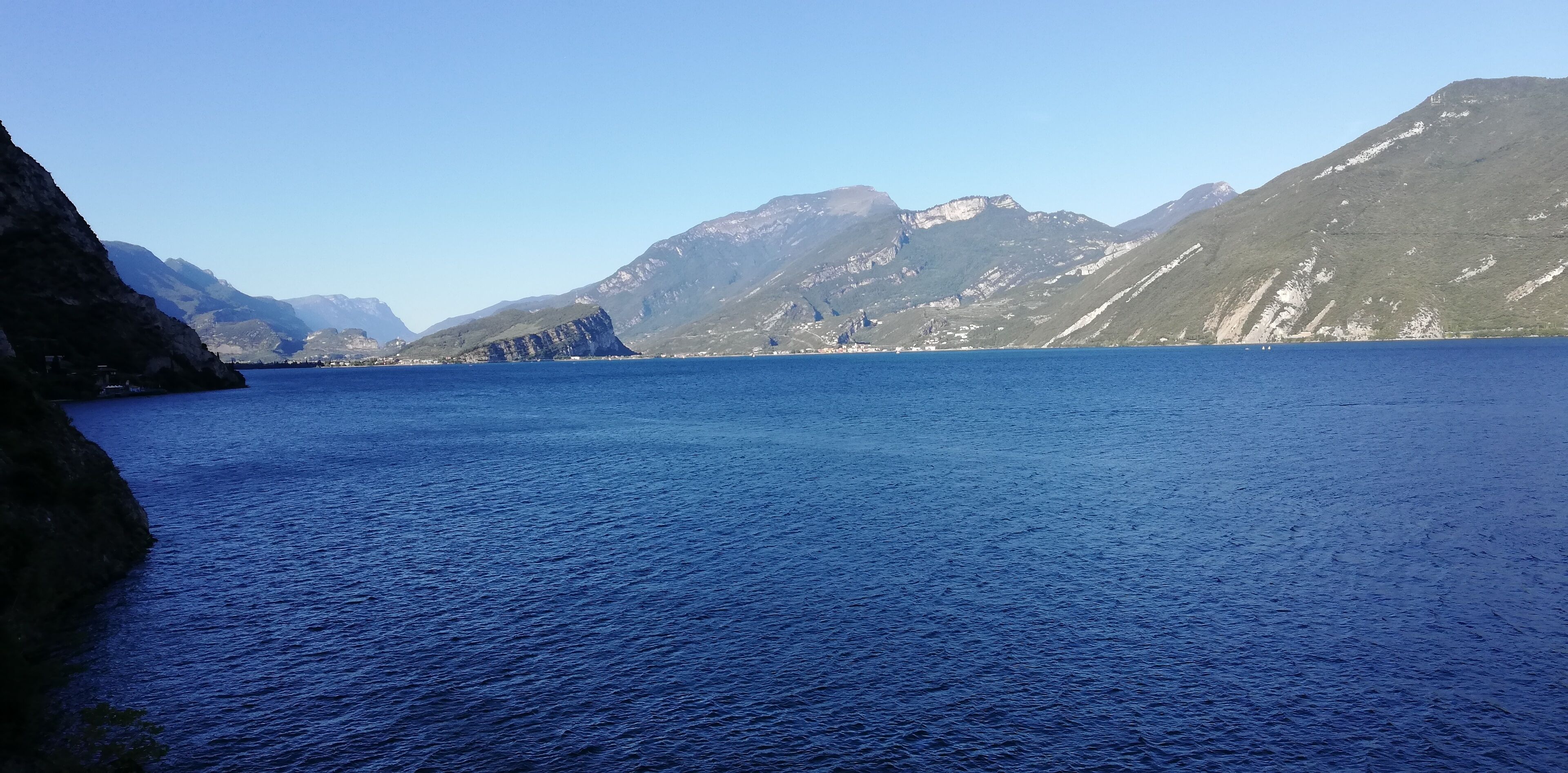 A calm body of water with mountains in the background.