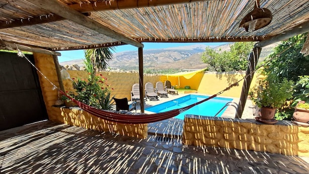 A patio with a hammock, a pool, and outdoor furniture. - Houses Amaro.   Spacious, comfortable, cozy and wonderful views  (0rgiva)