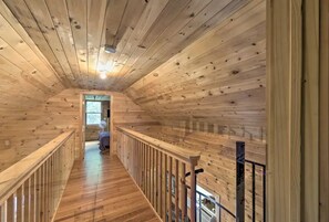 Cozy cabin-style room with a sloped ceiling and wooden floor.