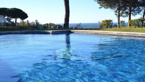 A clear swimming pool with a view of the sea and trees in the background. - Twin villas with large pool and sea views near Barcelona. Free wifi, a / c (Sant Pol de Mar Barcelona)