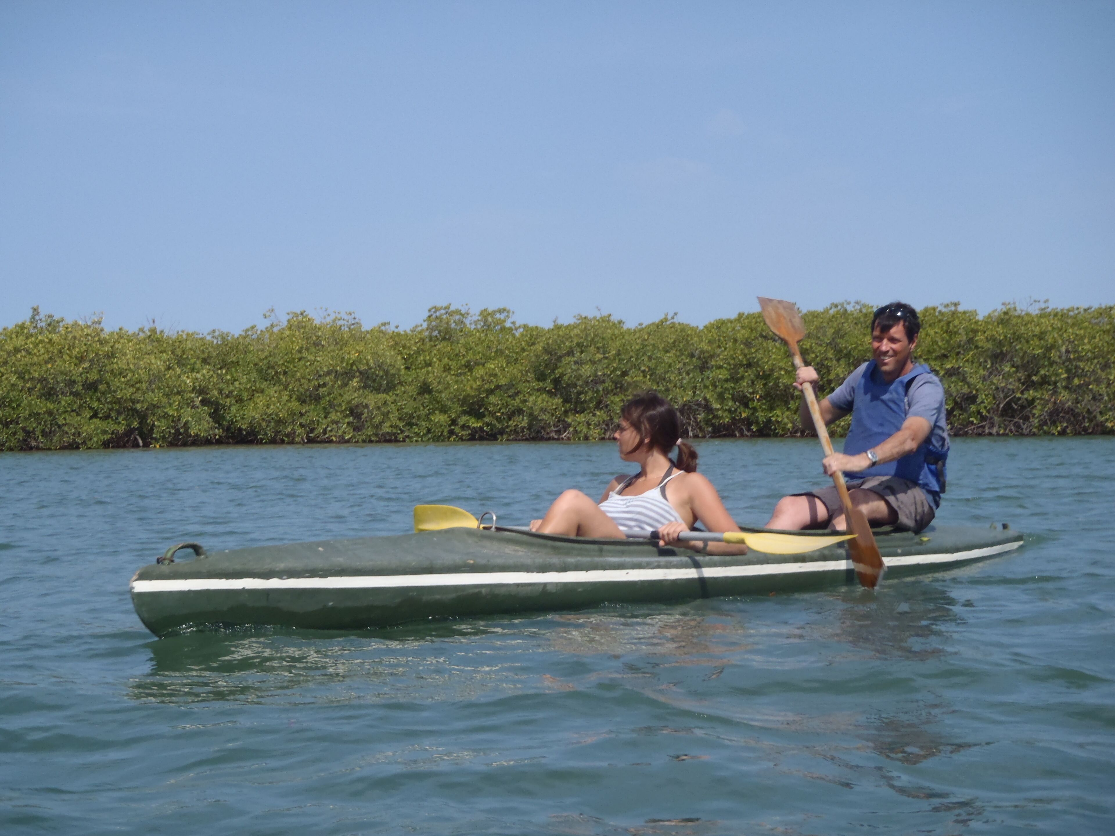 Dos personas en un bote pequeño sobre aguas tranquilas.