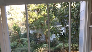 A covered porch with a wicker sofa and a small table with seashells.