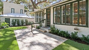 Uma casa com um alpendre pavimentado, uma escadaria e uma janela lateral.