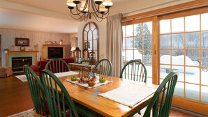 A dining area with a wooden table, green chairs, and a chandelier. - Enjoy each season's weather in historic Manchester.   Plenty to do year round!! (Manchester)