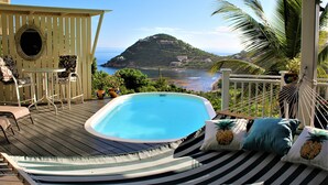 A hot tub on a wooden deck with a view of a mountain and ocean. - 4 bedroom, 4 bathroom. Private Pool, Ocean views. Chocolate Hole, Cruz Bay. (St. John, VI)