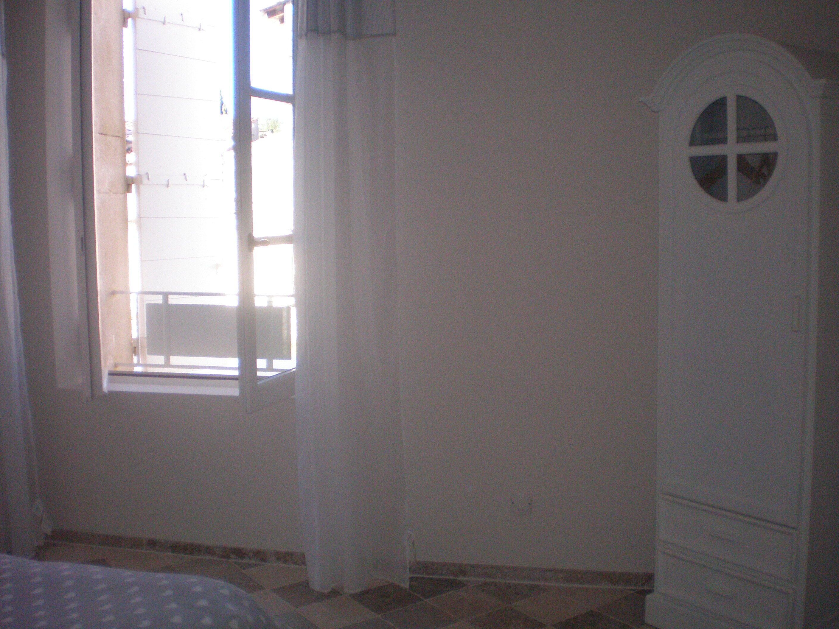 A room with a window, a bed, and a wardrobe.