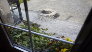 En stenpejs i en gårdhave med udsigt til et vindue.
