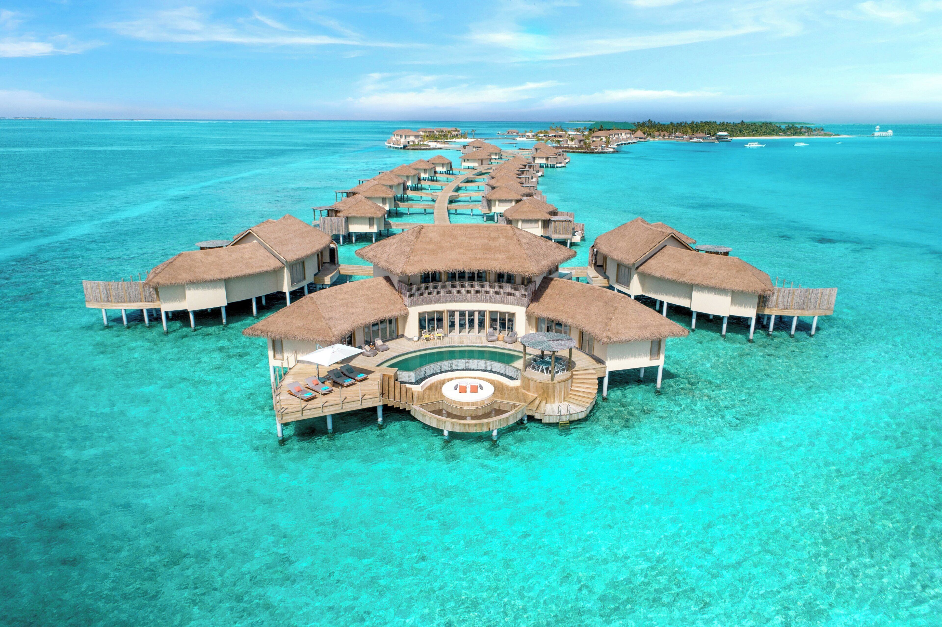 An overwater bungalows with a central pool and lounge area.
