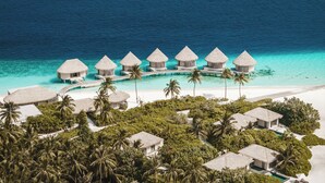 An aerial view of a resort with overwater bungalows, a beach, and lush greenery. - InterContinental Maldives Maamunagau Resort by IHG (Maamunagau Island)