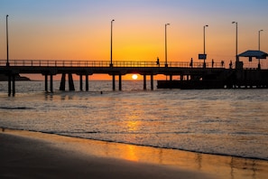 A pier extending into calm waters with a sunset in the background. - Holiday Inn Piura by IHG (Piura)