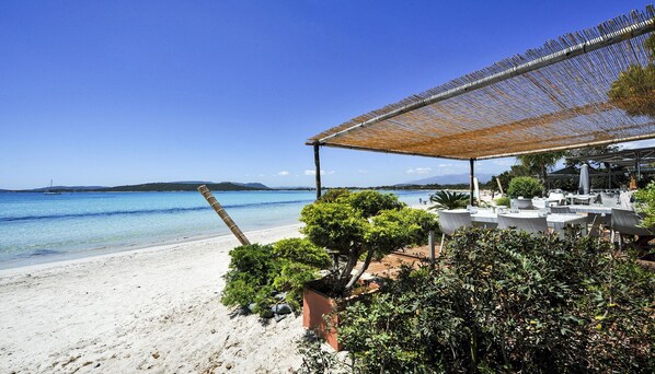 Enjoy meals with a view of the sea and distant hills from this beachfront dining area.