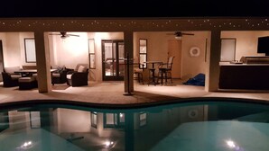 A poolside area with a seating arrangement, a table, and a ceiling fan. - Clean 3 Bed/2 bath home w/ pool, BBQ & covered patio, locked RV & boat parking (Lake Havasu City)