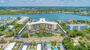 Um hotel grande com um pátio central, rodeado por uma marina e vista para a água.