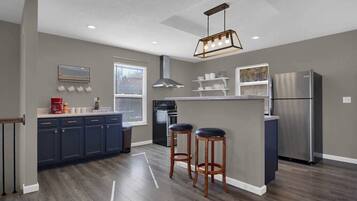 Een koelkast met diepvriezer, een microgolfoven, een oven, een kookplaat