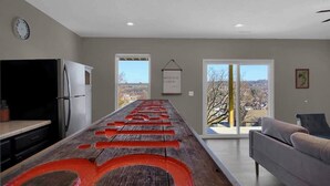 A modern kitchen with a long island, a refrigerator, and a dining area with a sofa. - The Bittersweet Inn: Brand new 6 bed 5 bath house (Hermann)