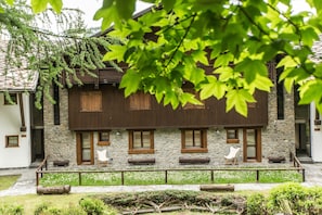 Il s’agit d’un bâtiment traditionnel aux murs de pierre et aux volets en bois, doté d’un espace extérieur abrité avec des chaises, où l’on peut s’asseoir.