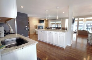 Enjoy cooking in this well-lit kitchen with a central island, ample counter space, and a stainless steel sink.