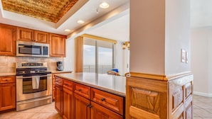A modern kitchen with wooden cabinets, stainless steel appliances, and a large island. - Toes In the Sand!!! (Pensacola)