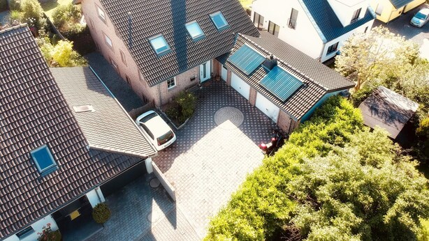 Un quartier résidentiel composé de plusieurs maisons, chacune dotée d’un toit en tuiles et d’un garage.