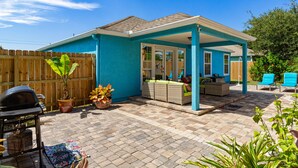 A backyard with a covered patio, a barbecue grill, and potted plants. - GOIN COASTAL Beach House, 3/2, Sleeps 10, 3 min Walk To The Beach  (St. Augustine)