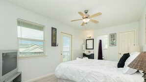 A bedroom with a bed, a ceiling fan, a television, and a window with blinds. - Phoenix Rising - Chill Beach Vibes, 4 Decks! (Surfside Beach)