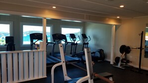 Un gimnasio con cintas de correr, una banca de pesas y una jaula para sentadillas.
