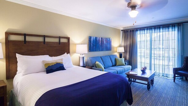 A hotel room with a large bed, a sofa, a coffee table, and a ceiling fan. - River Walk Resort at Loon studio, kitchenette, balcony, mount, river view, 5 fl (Lincoln)