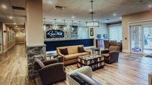 A spacious lobby with a stone accent wall, a neon sign, and a seating area with sofas and a coffee table. - River Walk Resort at Loon studio, kitchenette, balcony, mount, river view, 5 fl (Lincoln)