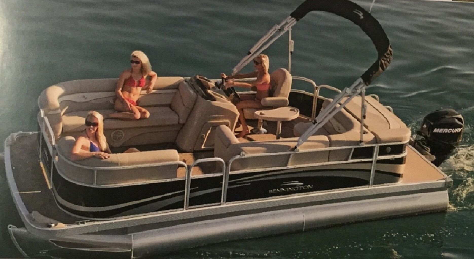 A motorboat with a covered seating area and a steering wheel.