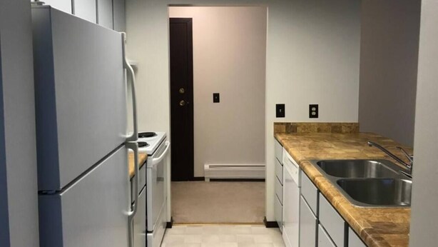 A compact kitchen with a refrigerator, stove, and sink.