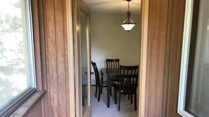 A hallway leading to a dining area with a table and chairs.