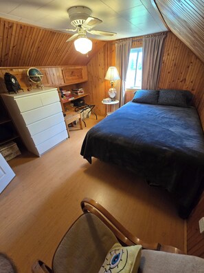 A cozy room with a bed, a desk, a chair, a dresser, and a ceiling fan. - Kawartha's Home/Cottage on Buckhorn Lake (Ennismore)