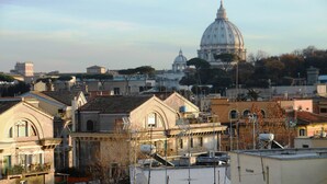 A cityscape with historic architecture, including a prominent dome and various buildings with traditional roofing.