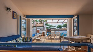 A cozy patio area with a blue sofa, a dining table, and chairs.