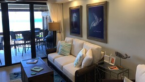 A living room with a sofa, a coffee table, a lamp, and framed artwork on the wall.